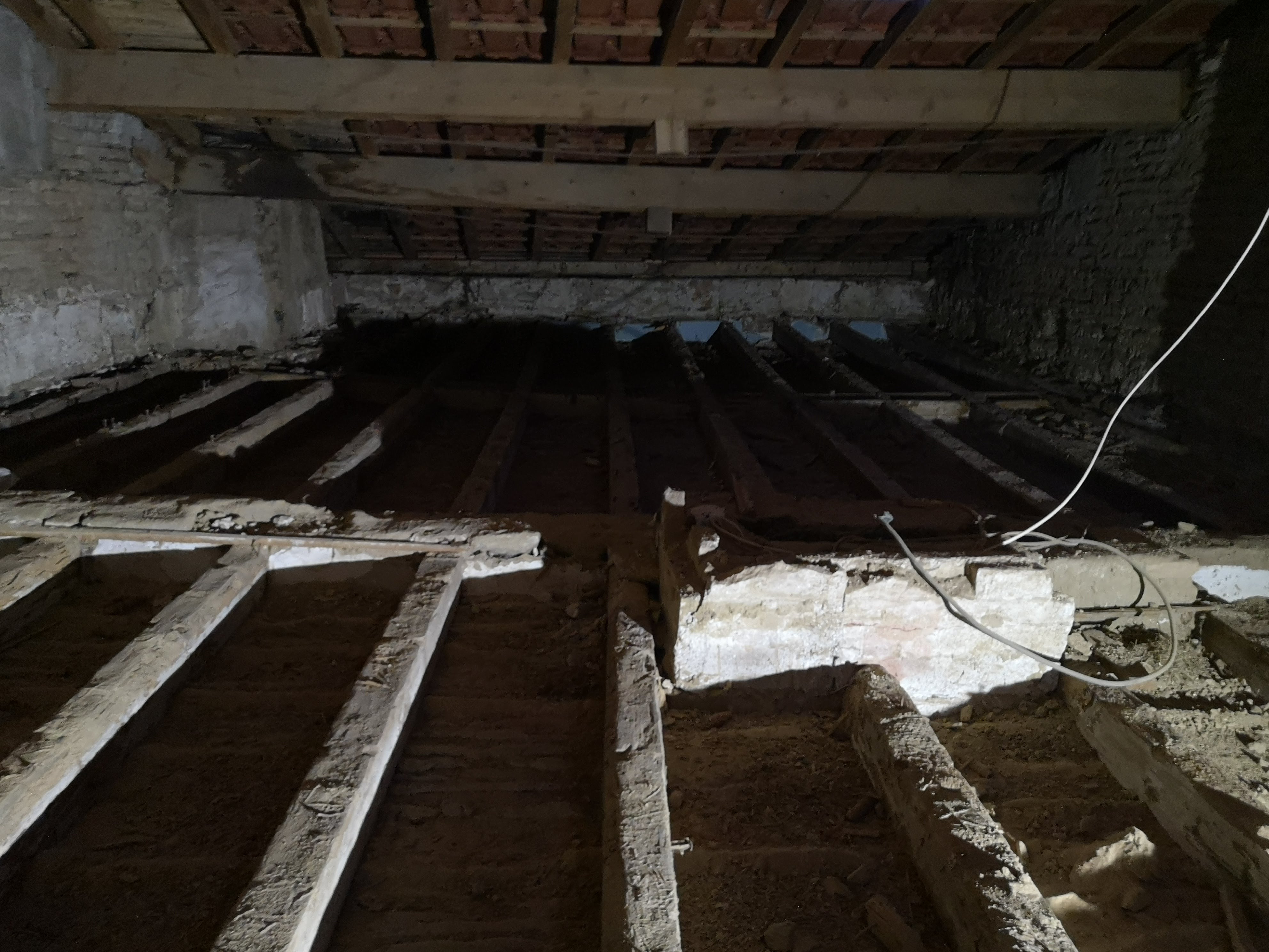 Dépose d’un ancien plancher et mise à nu des solives dans une maison ancienne