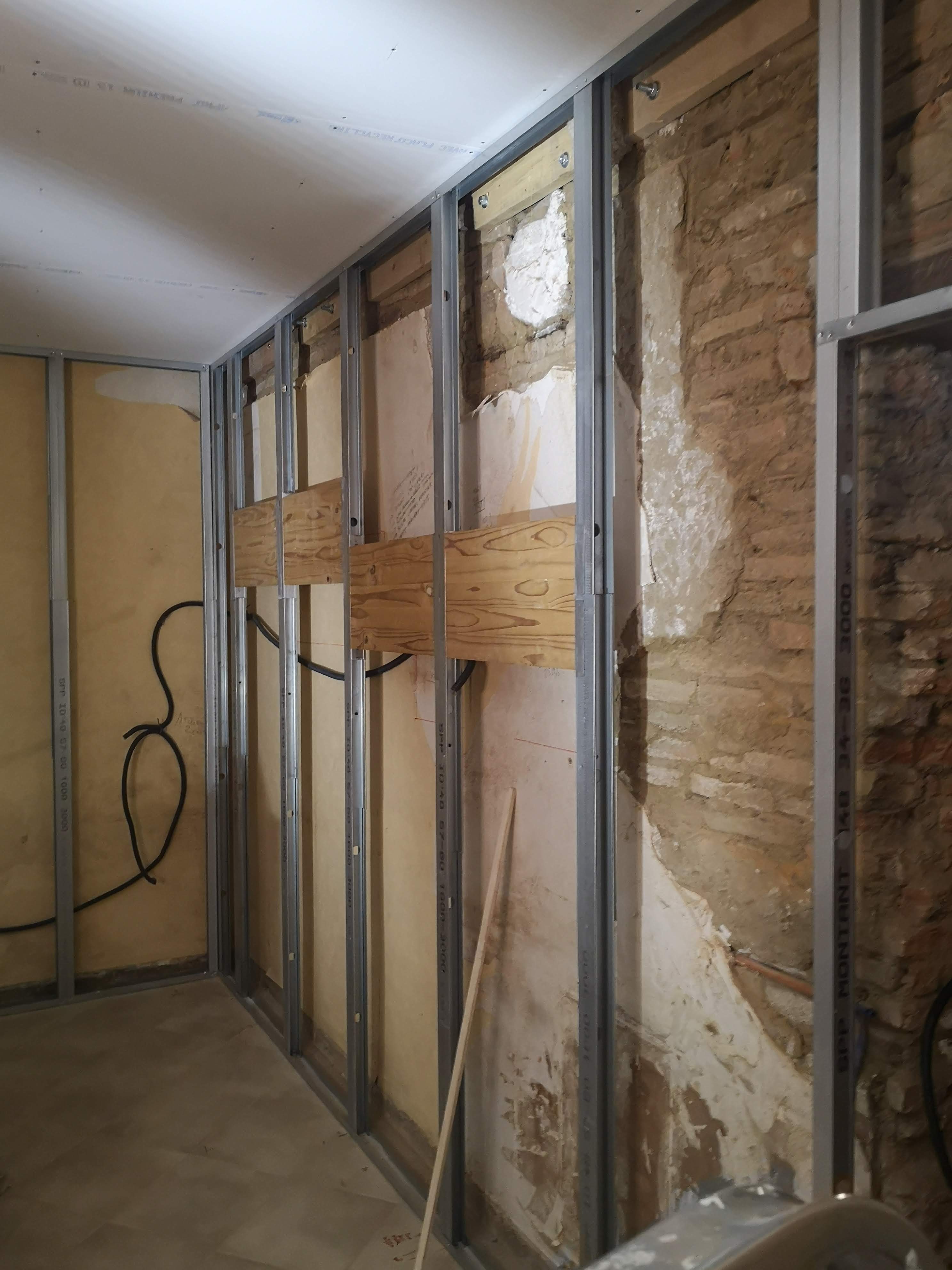 Création d’un doublage sur ossature métallique devant un mur ancien
