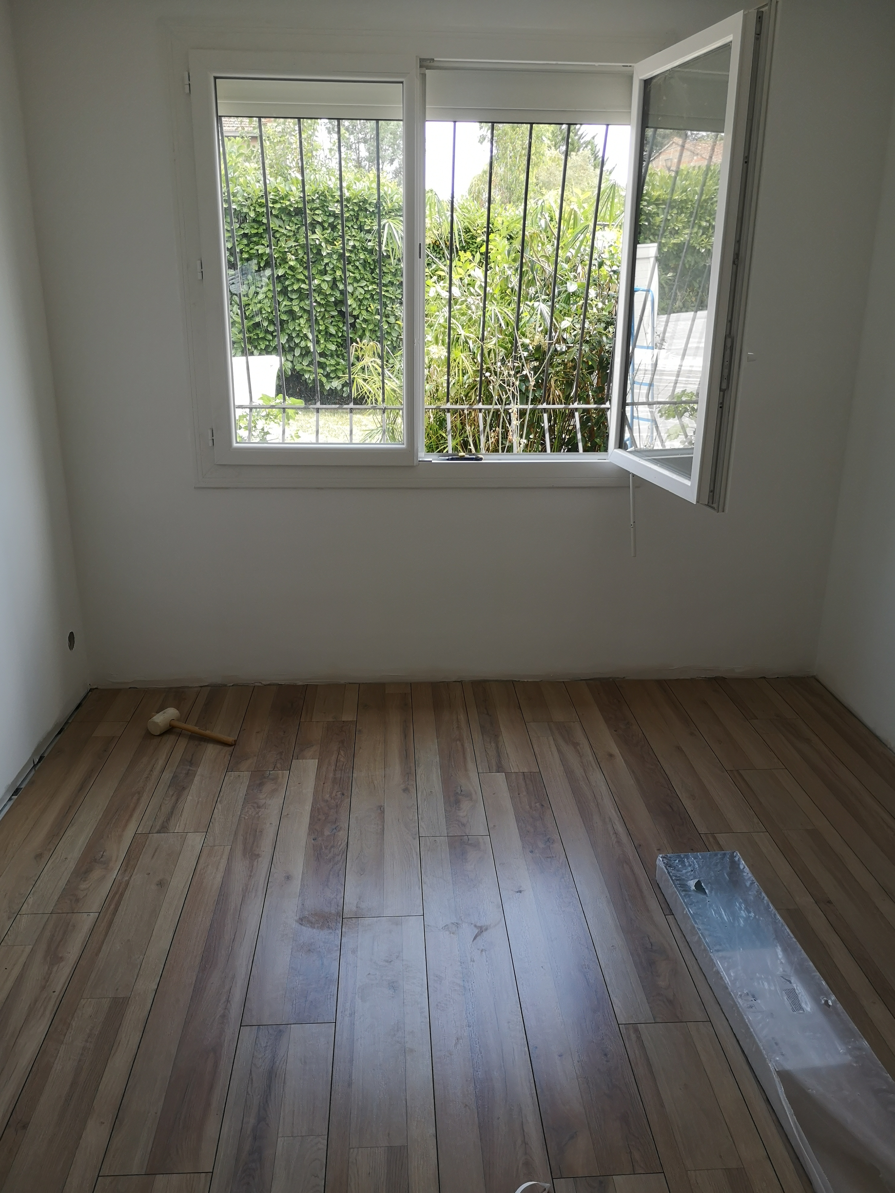 Pose d’un revêtement de sol imitation parquet dans une chambre