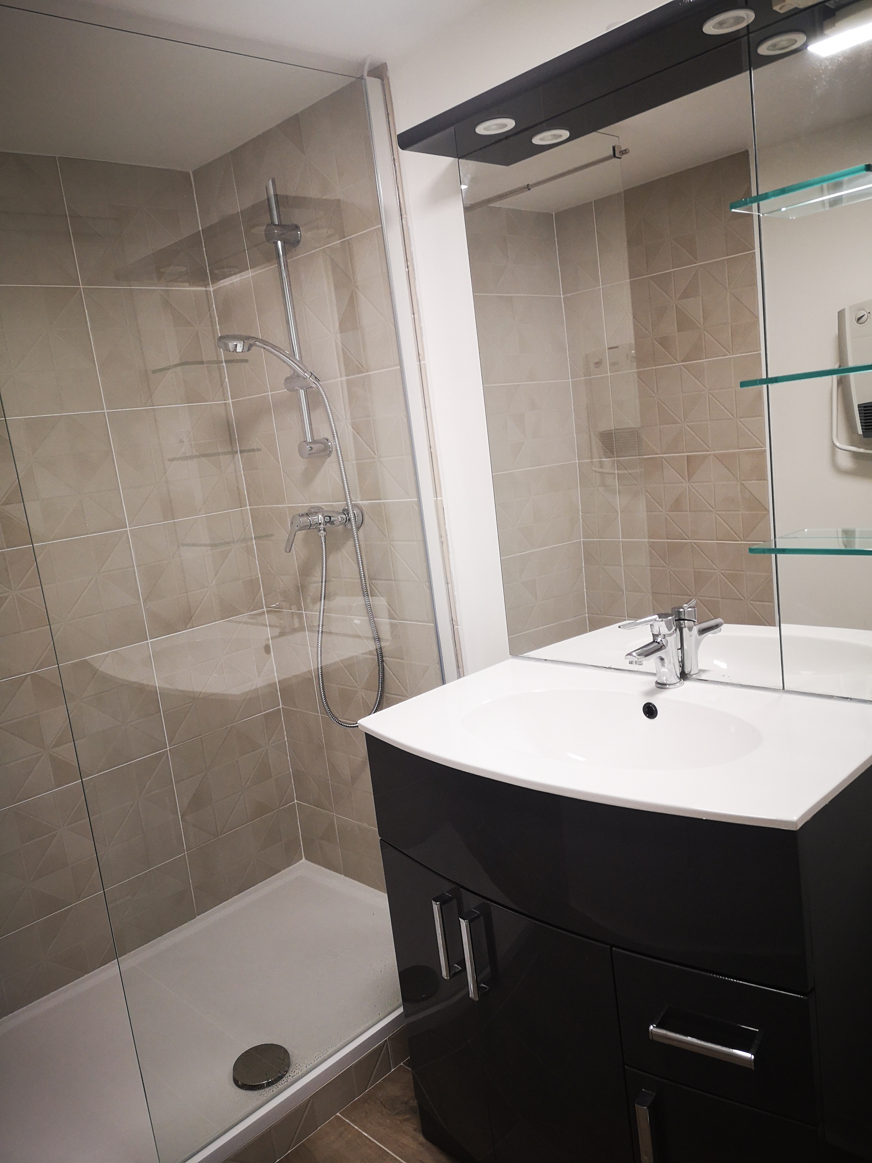 Rénovation complète d’une salle de bain avec douche, carrelage mural et meuble vasque